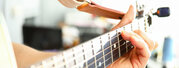 Man plays guitar, male hand holds neck guitar