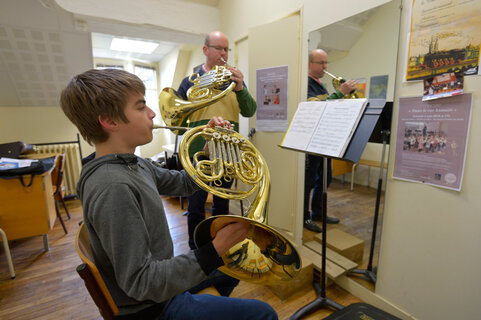 Élève jouant du cor d'harmonie avec son professeur dans une salle de cours du Conservatoire de Niort